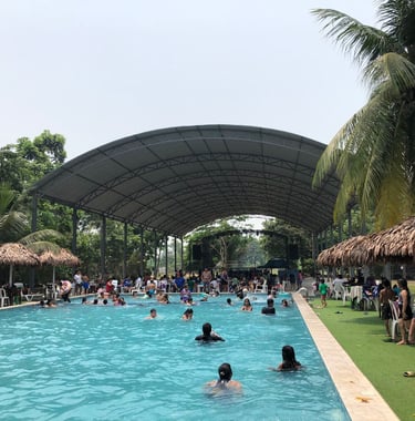 Families swimming in pool at Centro Recreacional Mokanrankon with a large arched metal roof