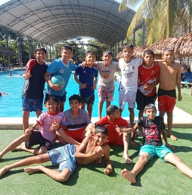 Smiling group of young boys posing together at the pool of Centro Recreacional Mokanranko Pucallpa