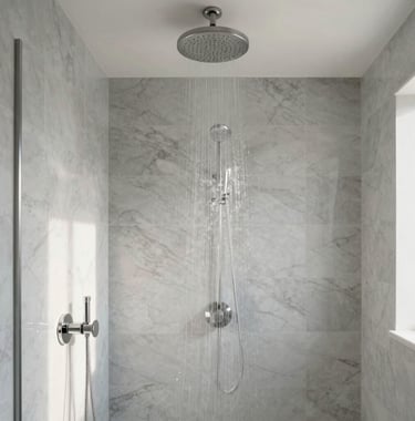 A bright and airy photograph of a luxury walk-in shower with large-format marble gray tiles and a ceiling-mounted rainfall showerhead. Soft light creates a tranquil, spa-like atmosphere in this modern Los Angeles home.