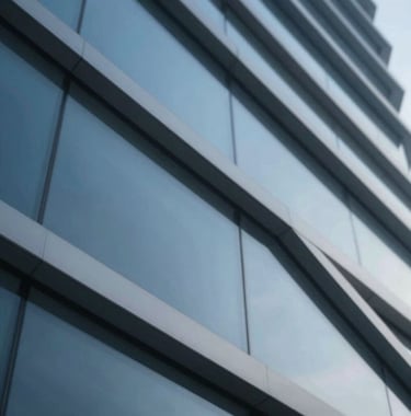 An abstract close-up of metal and glass architectural elements. Strong diagonal lines suggest movement and forward-thinking. The color palette centers on #2B4E6B and metallic greys.