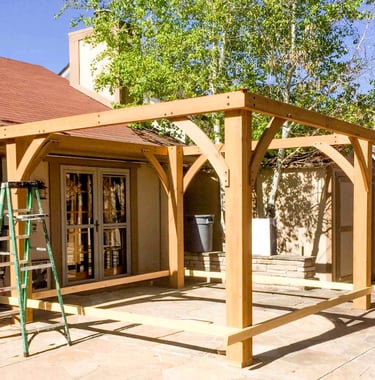 Building the heavy wood frame for a brand-new backyard pergola in Golden, Colorado.