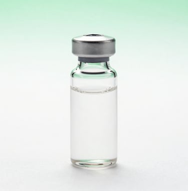 Professional studio photography of a translucent pharmaceutical vial against a crisp white background with a soft green gradient. The lighting is clinical and premium, emphasizing purity.