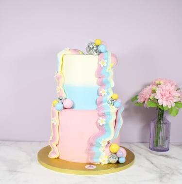 Tarta personalizada de dos pisos con diseño moderno en tonos pastel, creada en Madrid
