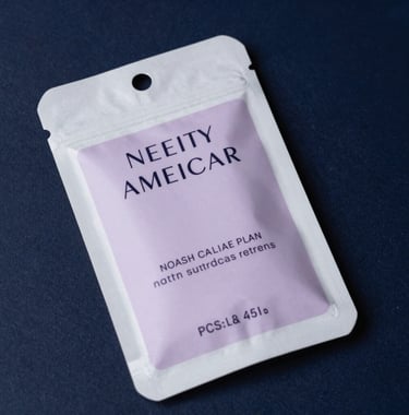 Close-up of high-end consumer product packaging for a beauty brand, featuring clean typography and soft lavender accents, set against a dark navy textured background. North American luxury aesthetic.