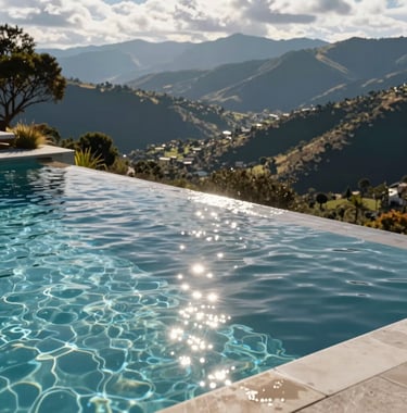 A crystal clear infinity pool at a luxury residence, overlooking a South American / Ecuadorian mountain landscape. Sunlight reflecting off the water, high-end lifestyle.