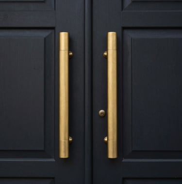 Close-up of a luxury property entrance in South America / Ecuador with metallic gold accents and a deep charcoal black door. Minimalist and corporate style.