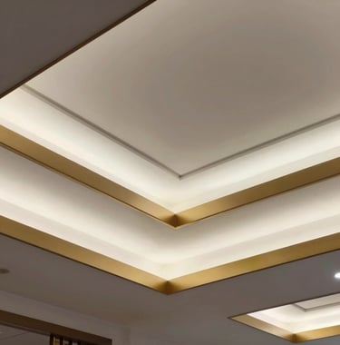 Detail of a custom false ceiling with layered geometric patterns, soft white recessed lighting, and a thin metallic gold border.
