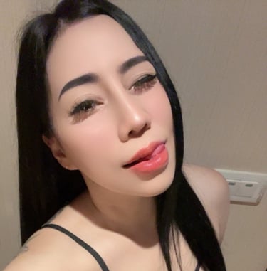 Lady wearing a black under garment and looking at the camera with her tongue out 