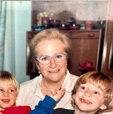 a woman in glasses and a child's hand holding a camera