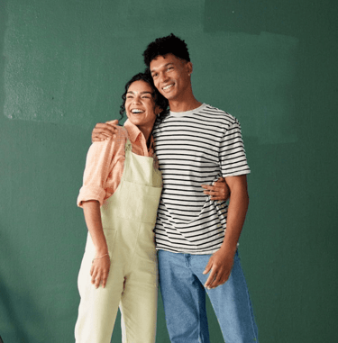 a man and woman standing in front of a green wall
