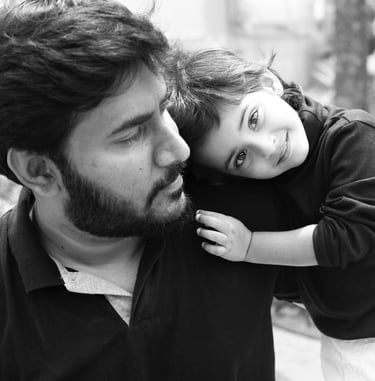 a father and his little child are smiling and hugging
