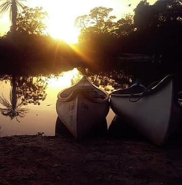 Een rustgevende afbeelding van het Marakissa River Camp, met hutten aan de oever van een kalme rivie