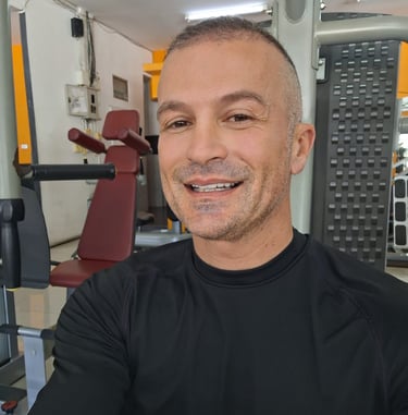 Man wearing black top sitting in a gym