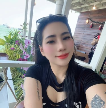 Lady wearing a black dress and tattoos showing on arms