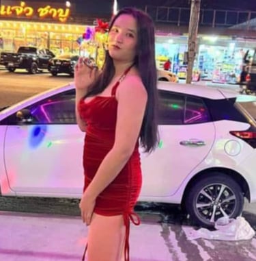 lady wearing short red dress with a white car in the background