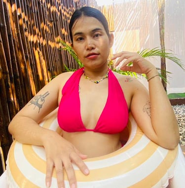 A lady wearing a red bikini sat in a bath tub