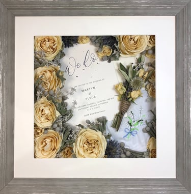 a memory box with keepsakes and a preserved wedding bouquet in a frame