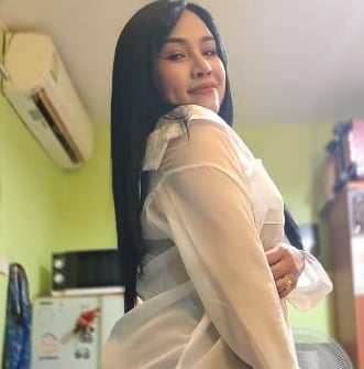 side view od lady wearing short black shorts and long sleeve cream blouse