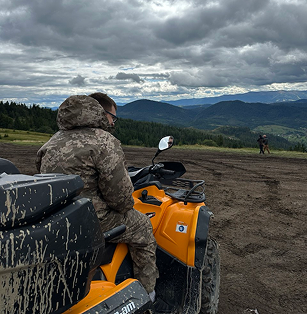 a man in a camouflager outfit is riding a atv