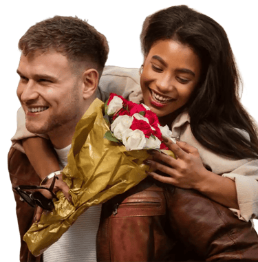 a man and woman smiling and holding flowers