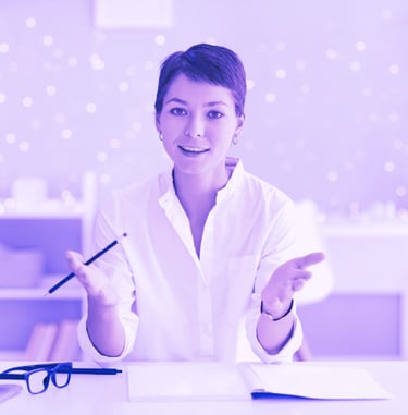 a woman in a white shirt and glasses sitting at a desk
