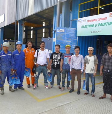 Industrial workers posing for a photo at a Jotun blasting and painting training course facility.