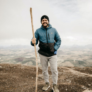 Image of man on hillside with hiking staff.