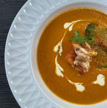 a bowl of soup with a lobster and broccoli