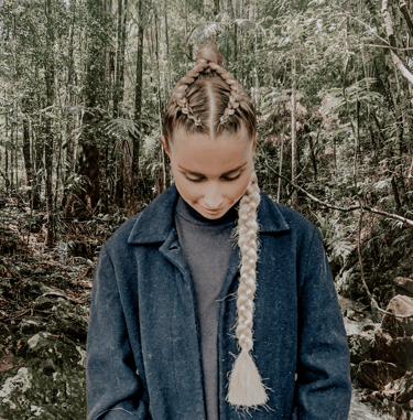 a woman with 2 corn rows into a braid plait.