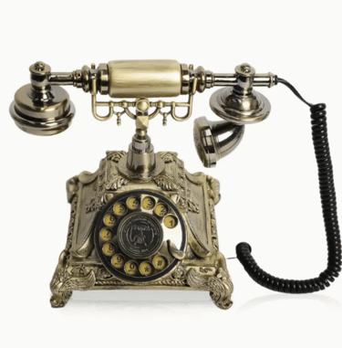 Vintage rotary dial telephone with ornate brass finish and classic coiled handset cord.