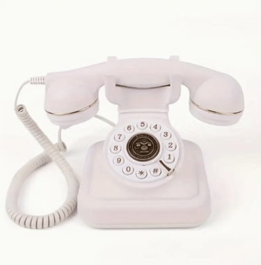 Vintage white rotary dial telephone with gold accents on a plain white background.