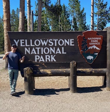 Ben Direen at Yellowstone National Park sign