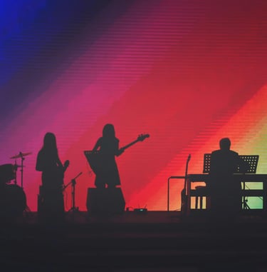 band on stage with rainbow background on screen
