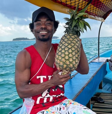 Local tour guide on a Mnemba Island Zanzibar day trip boat tour holding a fresh pineapple for tourists