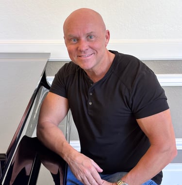 Composer Mark Bulmer sitting at the piano