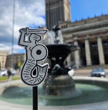 Magnes z Syrenką Warszawską na tle Pałacu Kultury