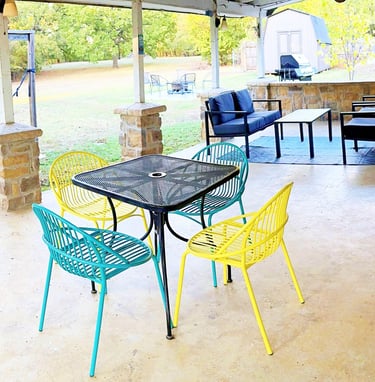 a patio with a table and chairs and a hammock
