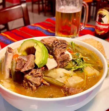 a bowl of soup with a beer and a beer