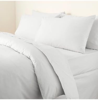 a bed with white sheets and pillows on it
