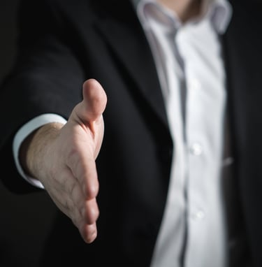 a man in a suit and tie is holding a hand out to a hand