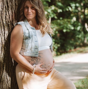 Babybauchshooting Coburg: Stolze werdende Mutter hält schützend die Hände auf ihren Bauch.