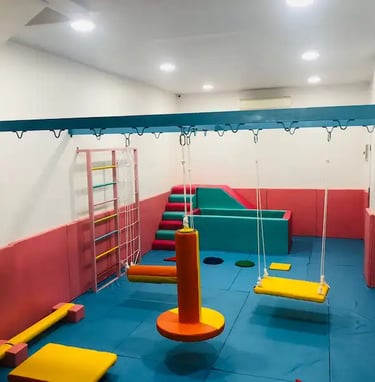 sebuah ruang sensori intergasi anak dengan ayunan perosotan dan kolam bola
