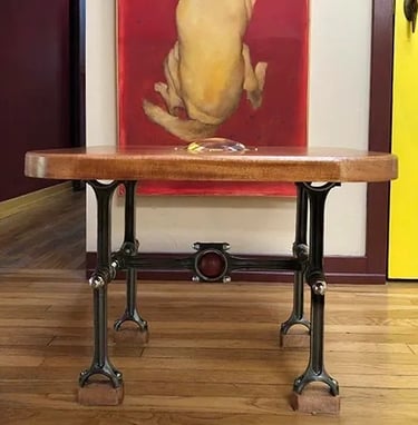 Industrial coffee table made of wood top and base made of engine rods.