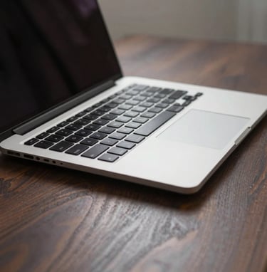 A close-up photograph of a sleek, high-end aluminum laptop on a dark wood desk in a minimalist studio in the North American / US, soft natural lighting highlighting professional design tools.