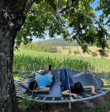 a man and woman laying on a hanging bed