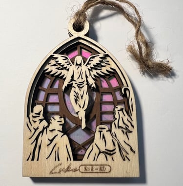 Wooden langing ornament with angel and figures over a stained glass style background