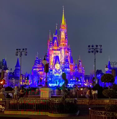 Cinderella Castle at Magic Kingdom Park is lit up at night.
