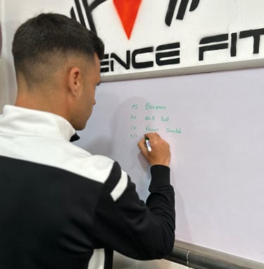 El entrenador anotando en la pizarra los ejercicios