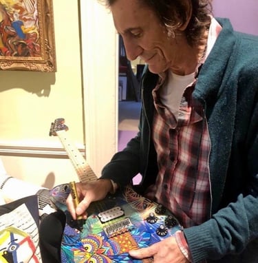 Ronnie Wood of the Rolling Stones singing - autographing my painted guitar.