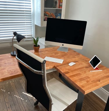 a custom mahogany stained l-shaped desk with a computer and tablet
